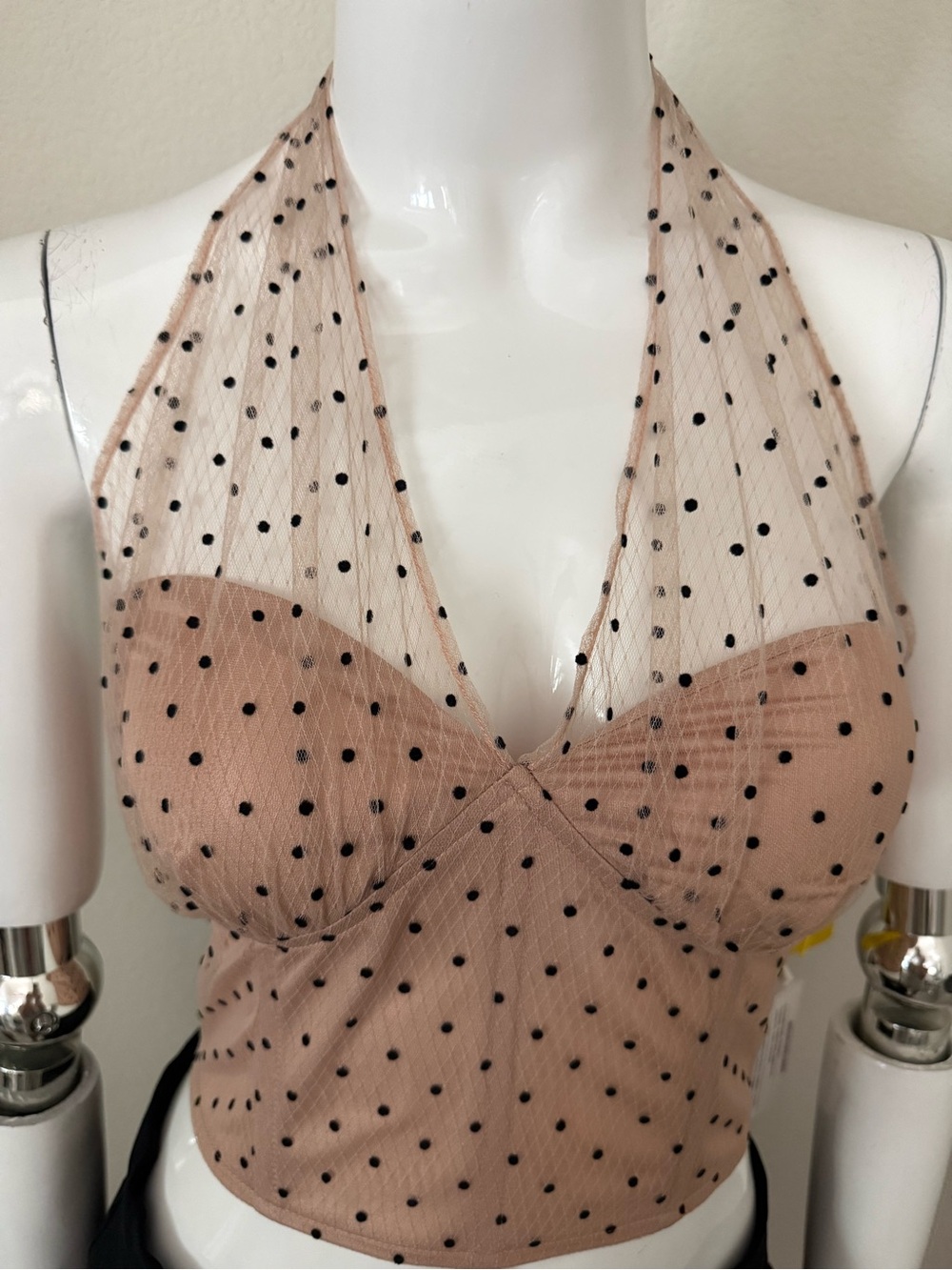 Bao Zong Black polka dot halter crop top on a nude background.